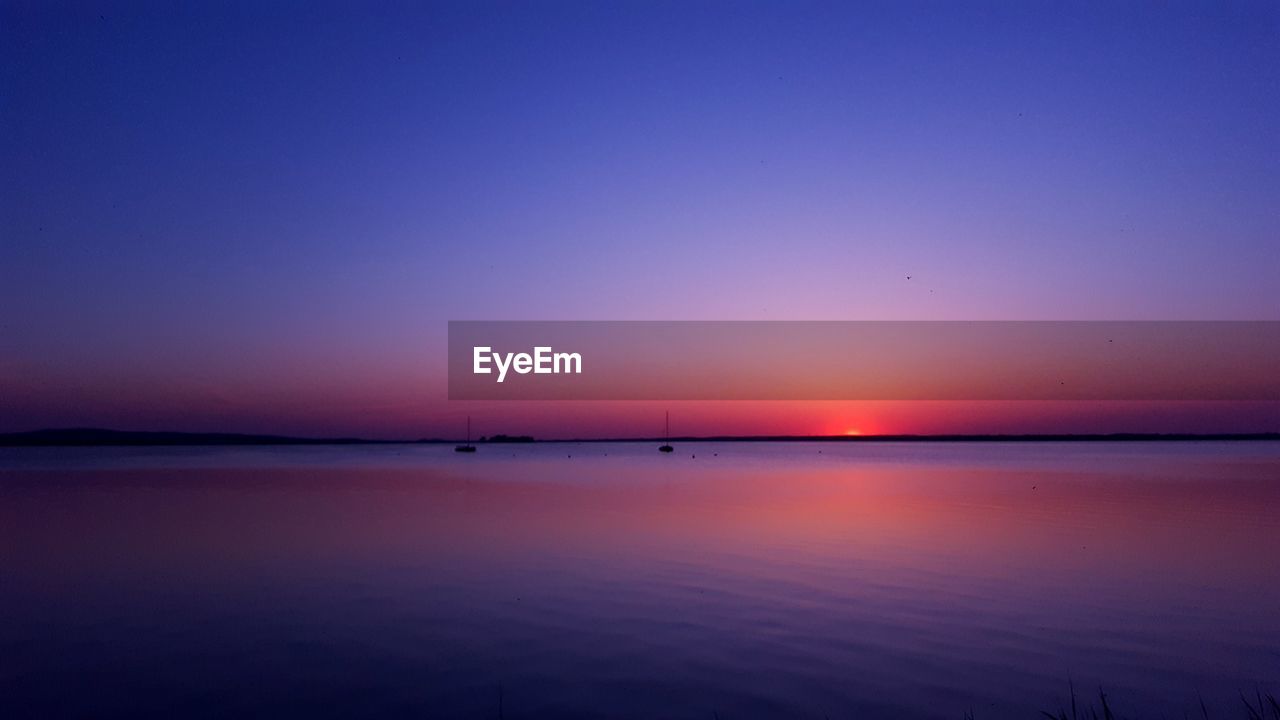 Scenic view of sea against romantic sky at sunset