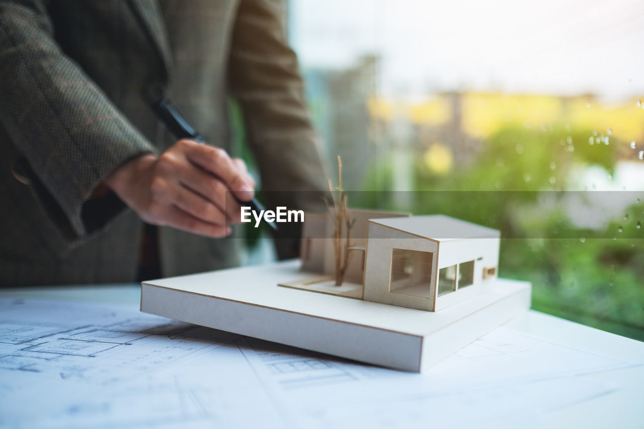 one person, adult, business, hand, occupation, planning, indoors, men, holding, business finance and industry, selective focus, architecture, day, working, table, midsection, office, close-up, creativity, businessman, focus on foreground