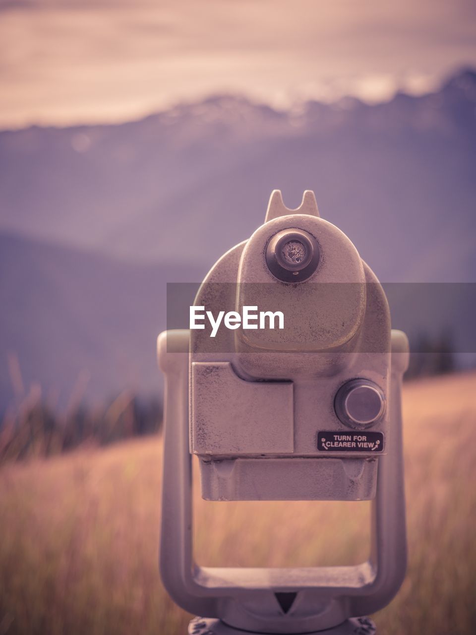 CLOSE-UP OF CAMERA AGAINST MOUNTAIN