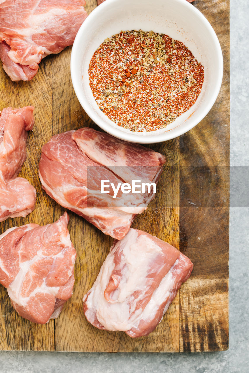 Pork shoulder and dry rub spices on cutting board still life