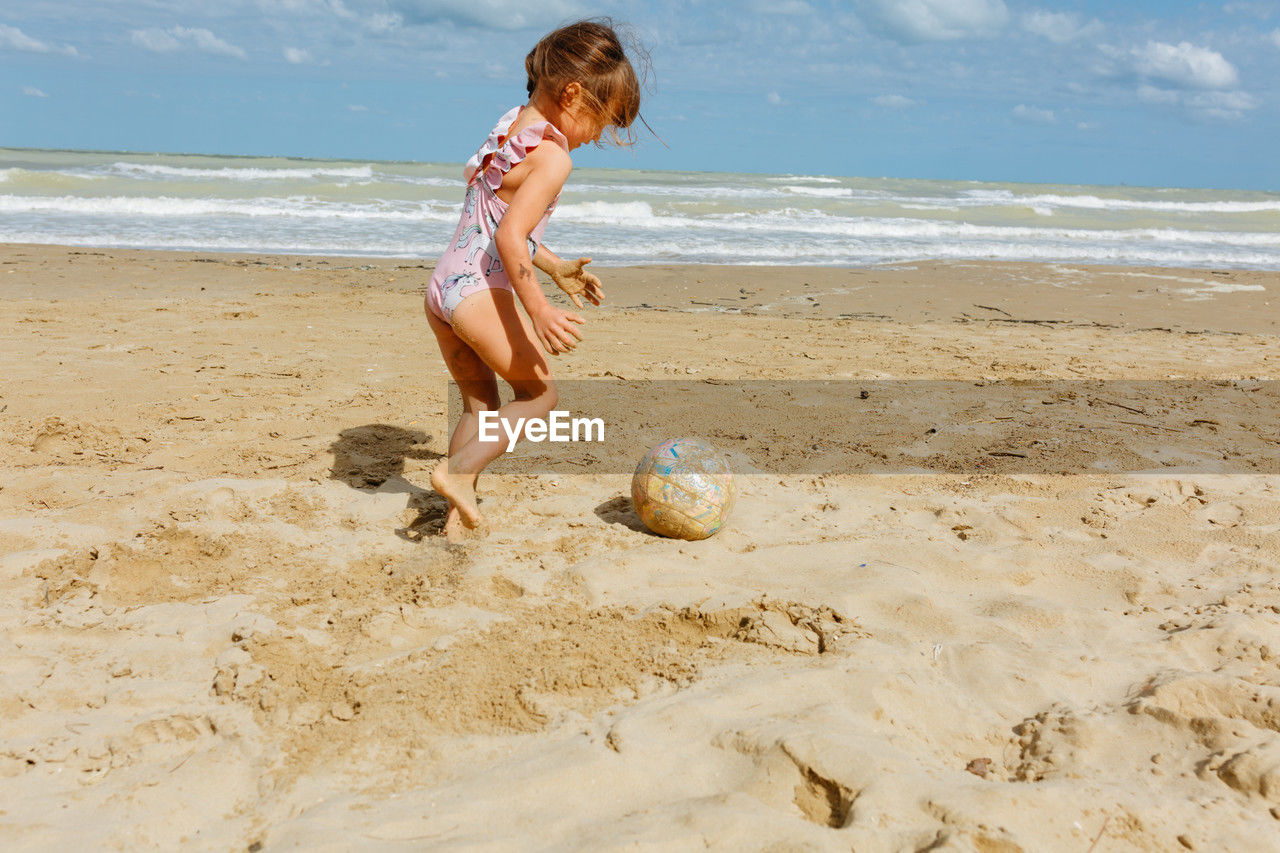 Girl playing with ball at beach