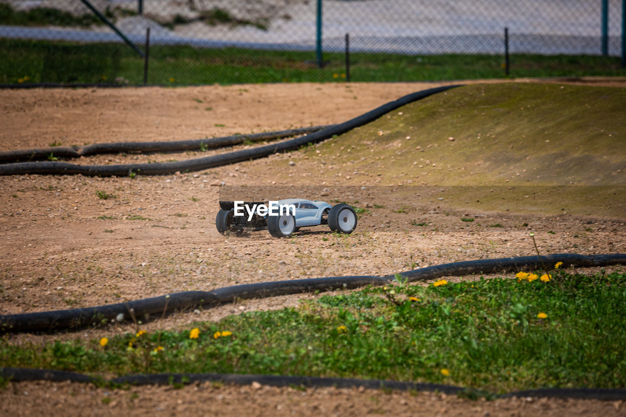 TOY CAR ON FIELD BY ROAD