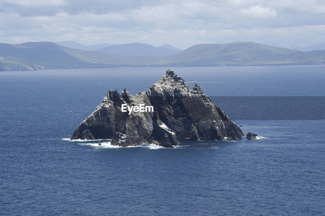 Scenic view of sea and mountains against sky