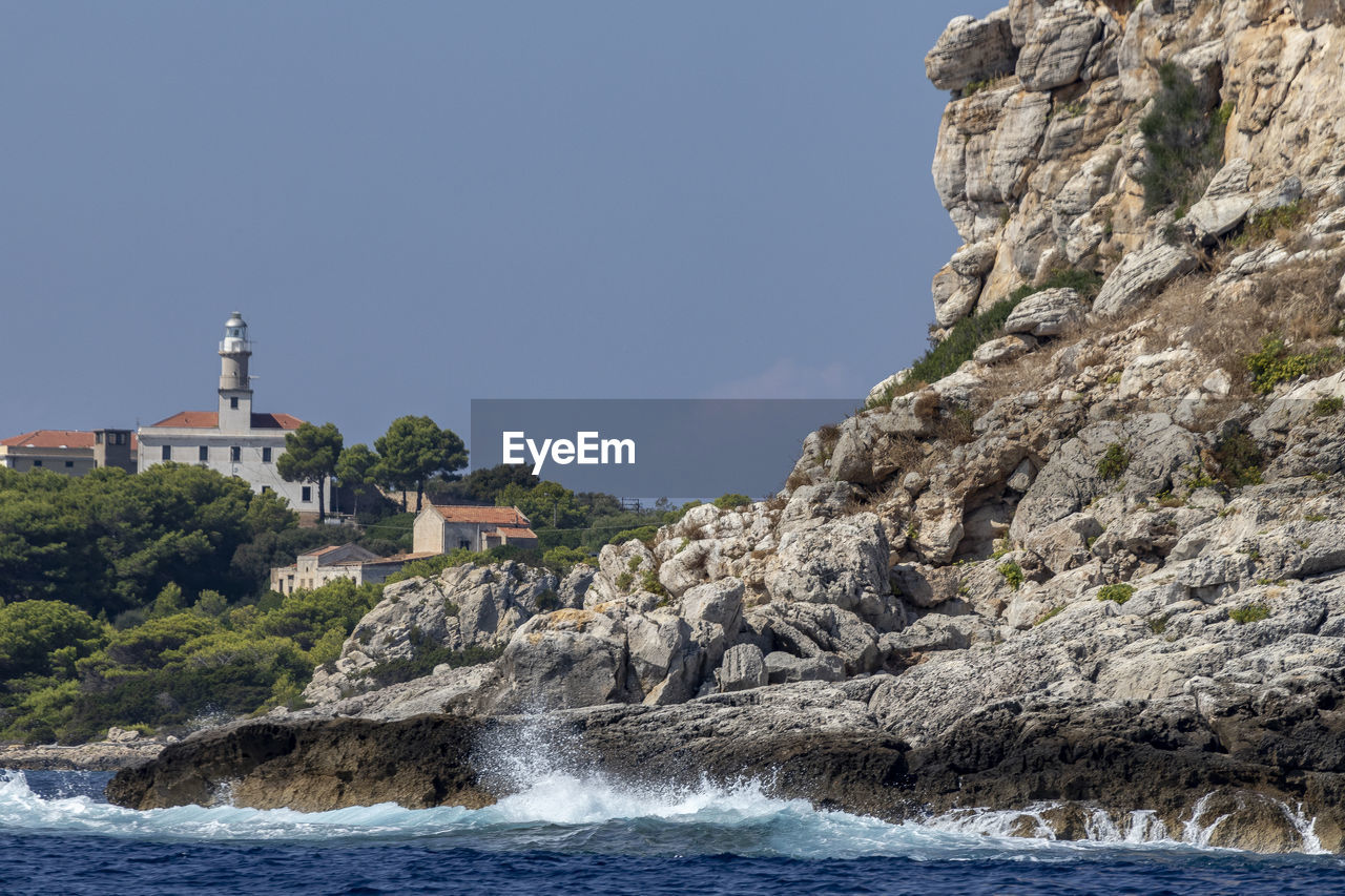 Scenic view of sea by buildings against clear sky