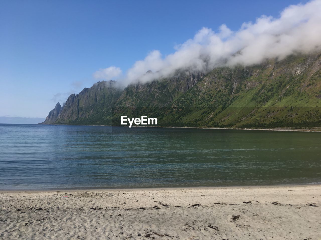 Scenic view of sea and mountains against sky