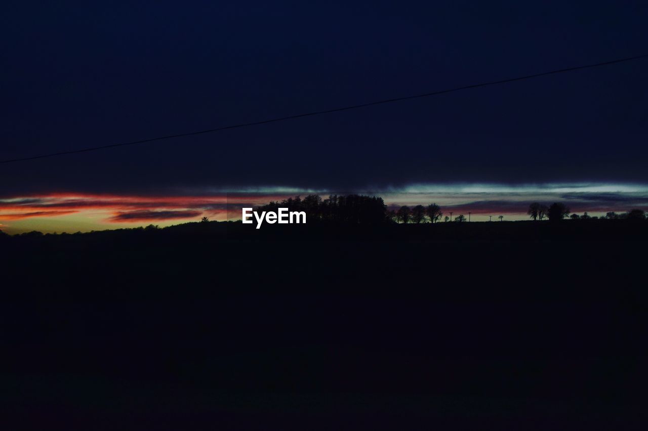 Silhouette landscape against sky at sunset