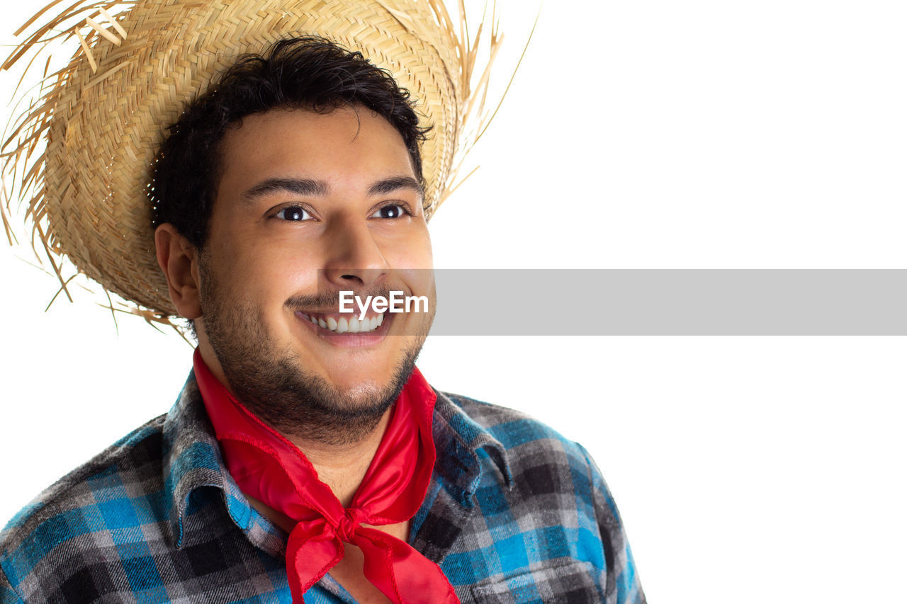 portrait, smiling, happiness, emotion, hairstyle, one person, adult, headshot, clothing, young adult, white background, cheerful, person, men, looking at camera, hat, human hair, facial hair, positive emotion, teeth, smile, studio shot, human face, cut out, copy space, beard, casual clothing, fashion accessory, fun, red, front view, joy, indoors, lifestyles
