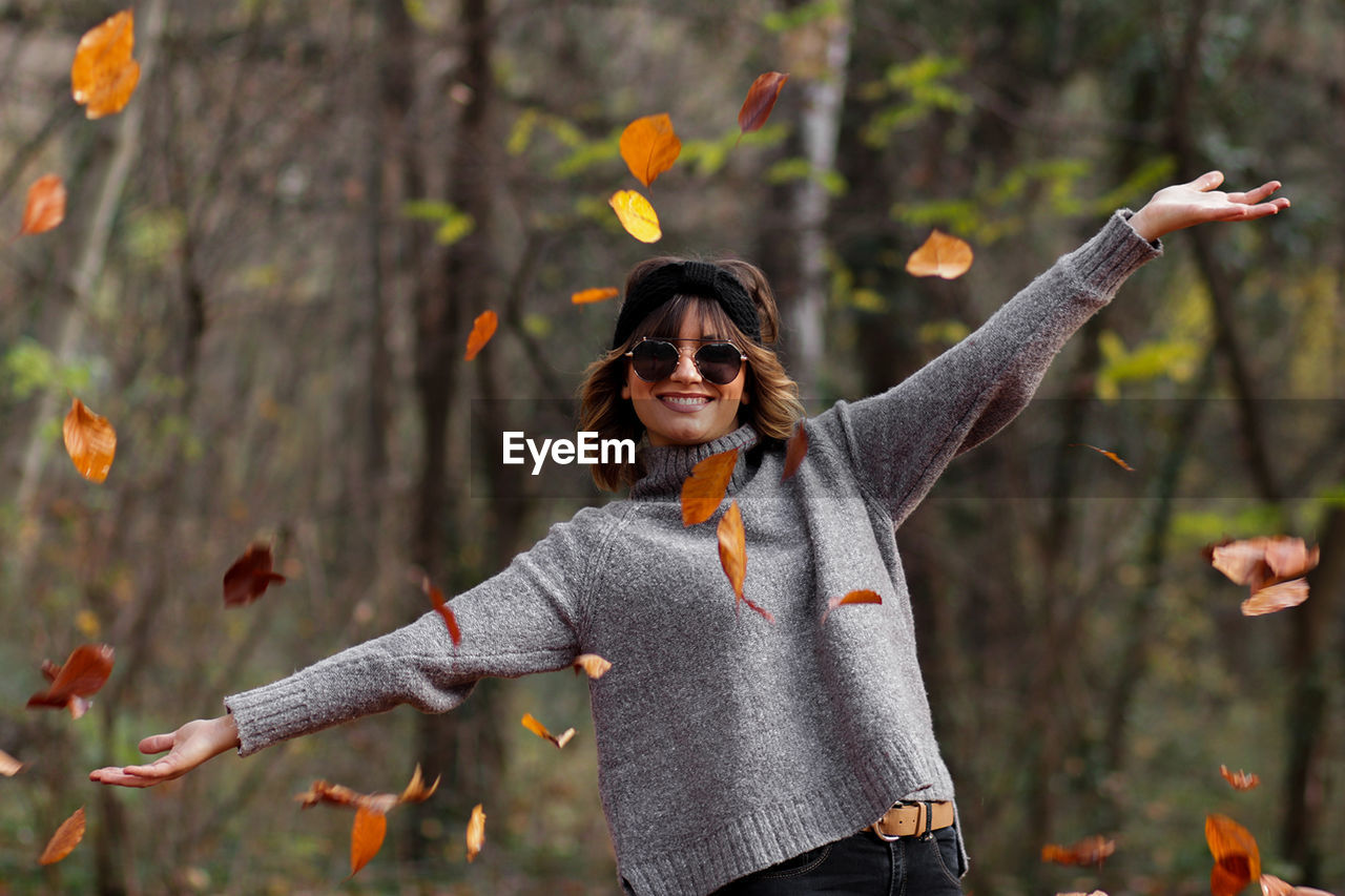 Young woman wearing warm clothing at public park during autumn