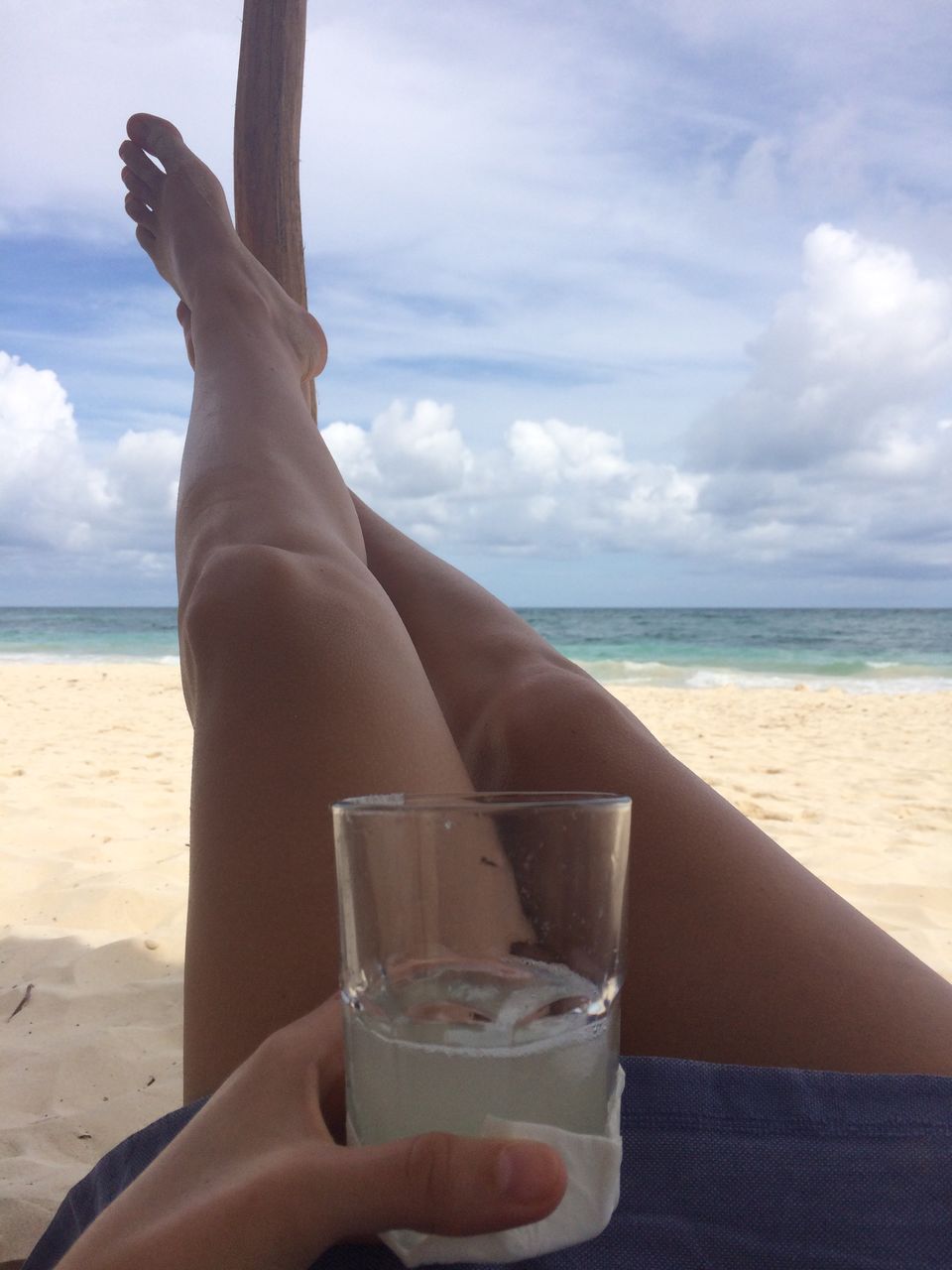 CLOSE-UP OF WOMAN WITH SUNGLASSES ON BEACH