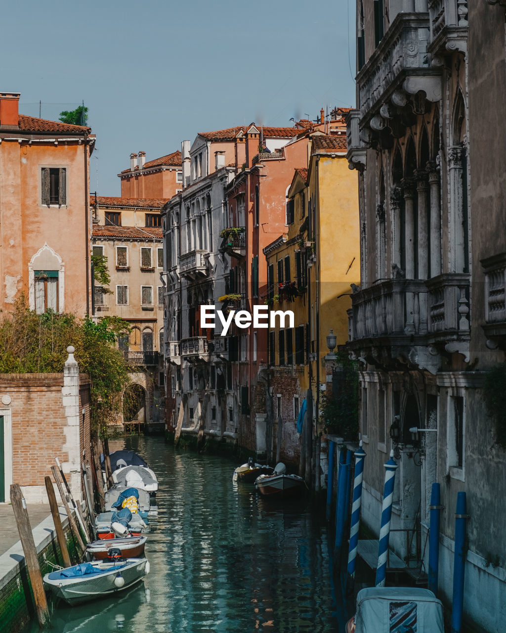 Boats in canal amidst buildings in city