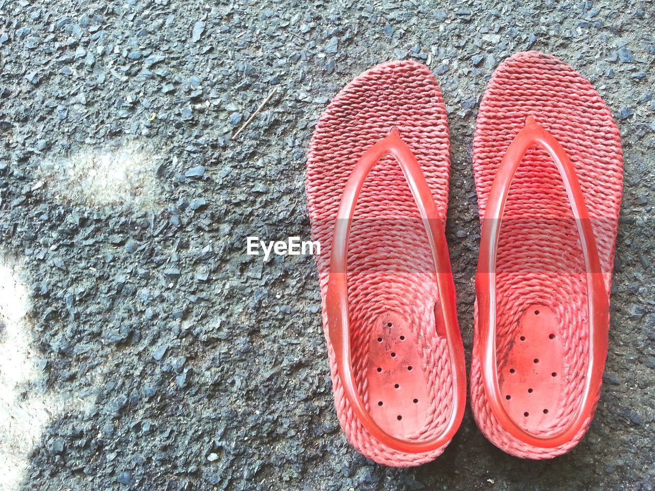 HIGH ANGLE VIEW OF RED SHOES ON SAND