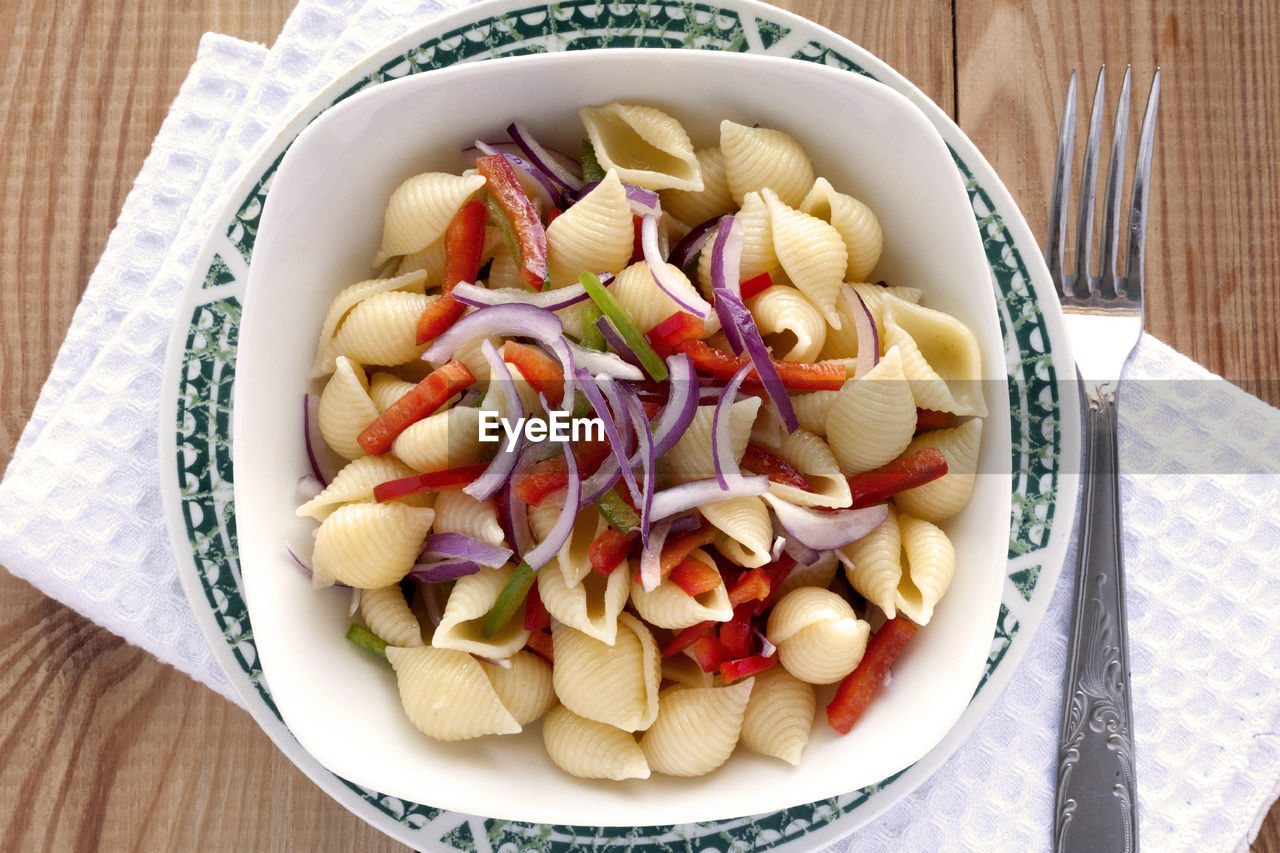 Close-up of vegetables in bowl on table. conchiglie pasta salad. 