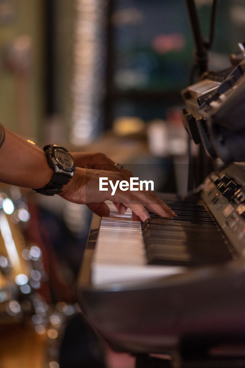 Cropped hands of person playing piano