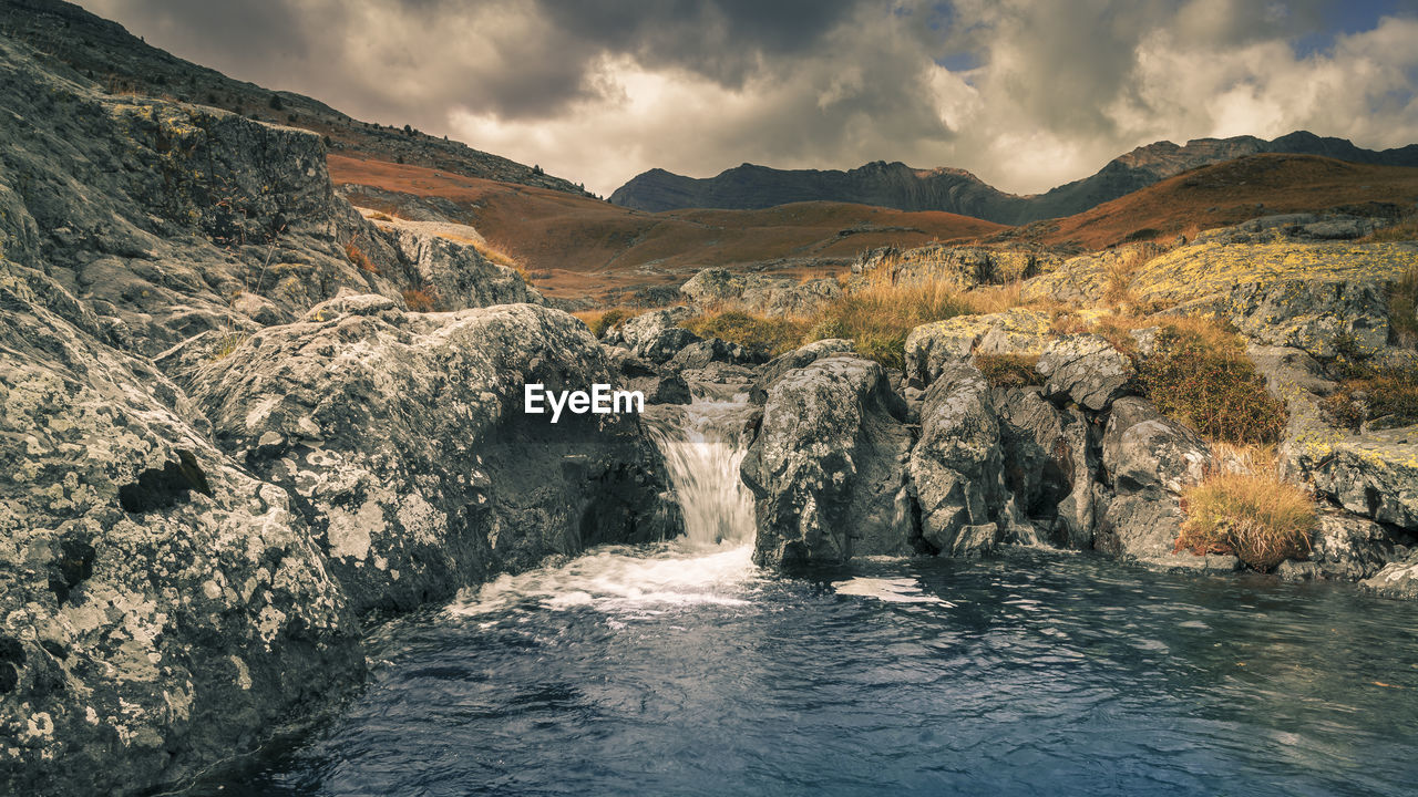 Scenic view of waterfall against sky