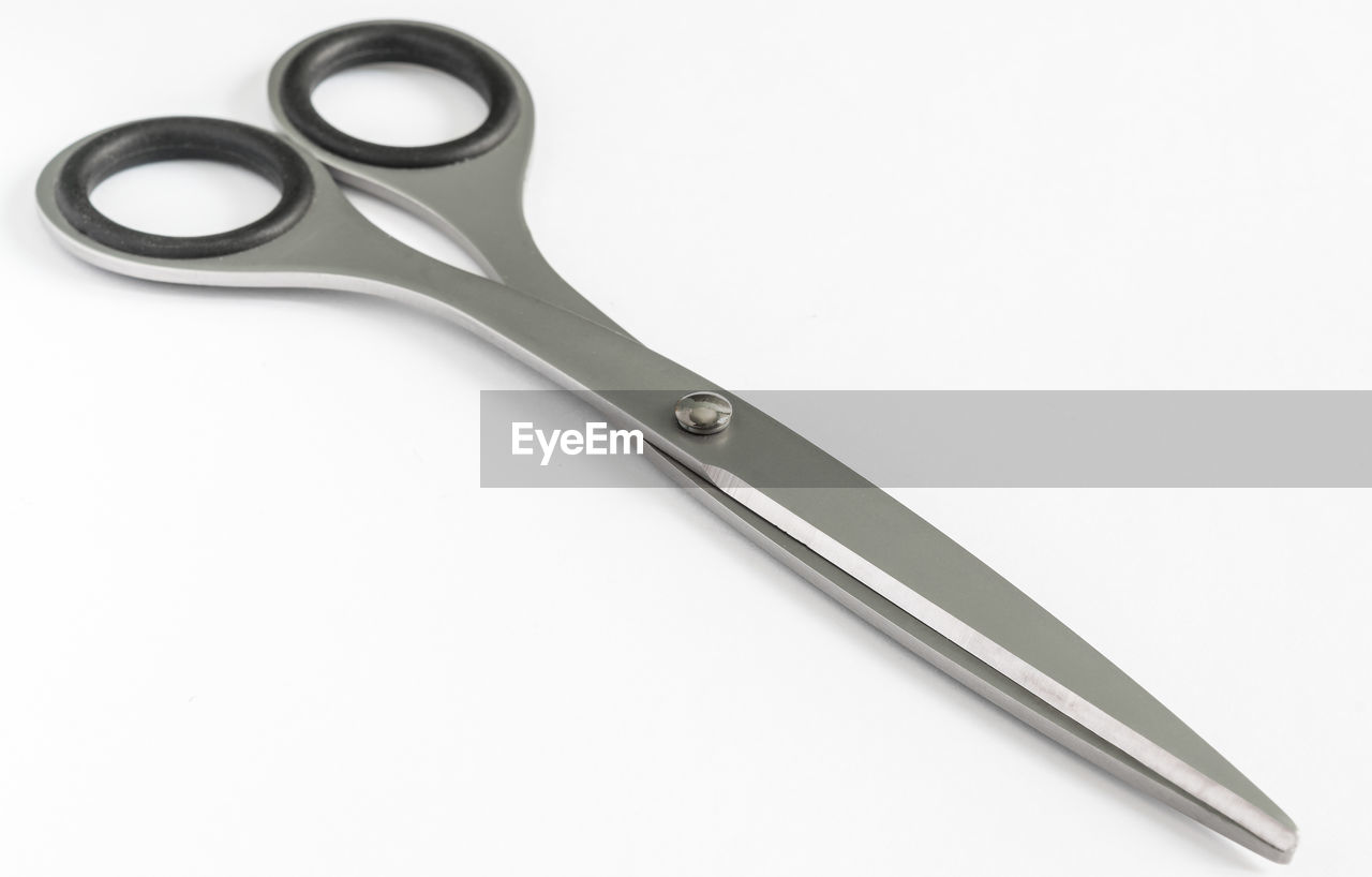 High angle view of haircutting scissors against white background