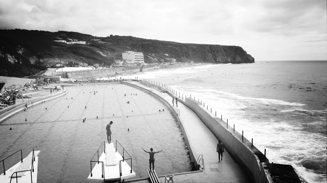 People in swimming pool against beach