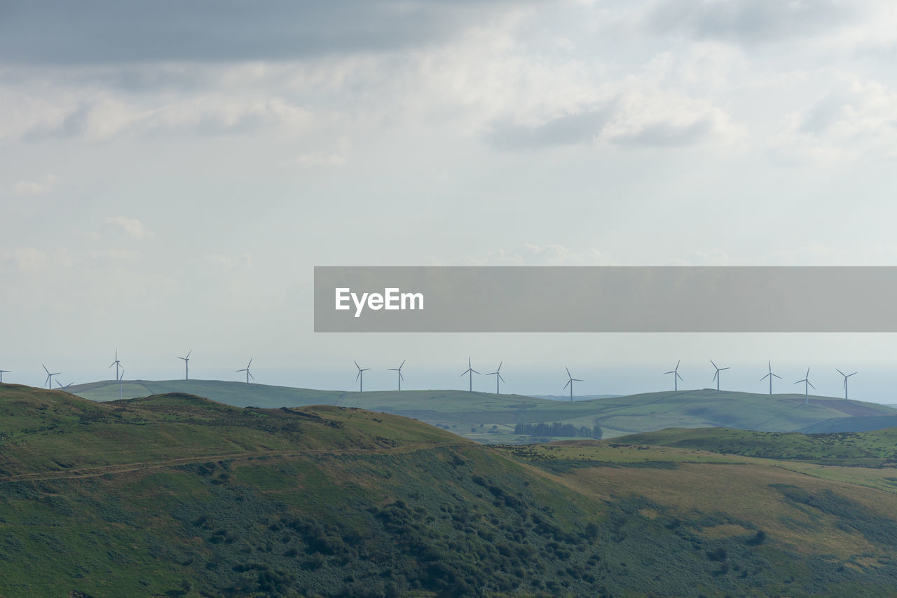 Scenic view of field against sky wind farm 