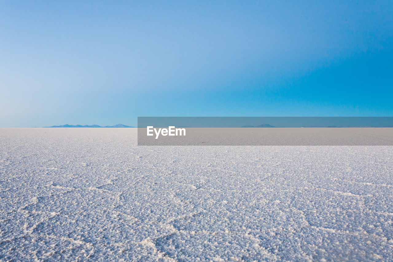 Scenic view of desert against clear blue sky