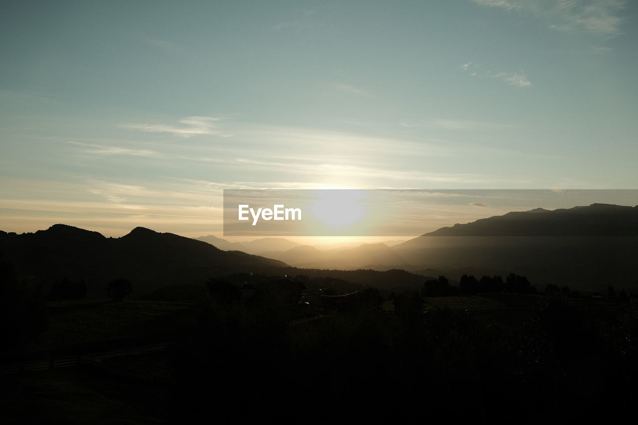 sky, mountain, scenics - nature, beauty in nature, landscape, environment, dawn, sunset, tranquility, nature, silhouette, tranquil scene, mountain range, horizon, sunlight, sun, cloud, no people, idyllic, outdoors, non-urban scene, sunbeam, light, evening, darkness, land, travel destinations, travel