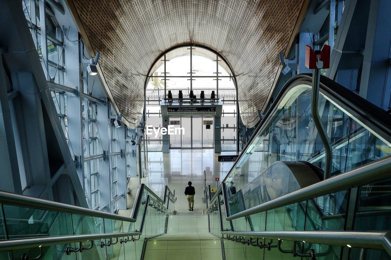 PEOPLE WALKING ON STAIRCASE IN BUILDING