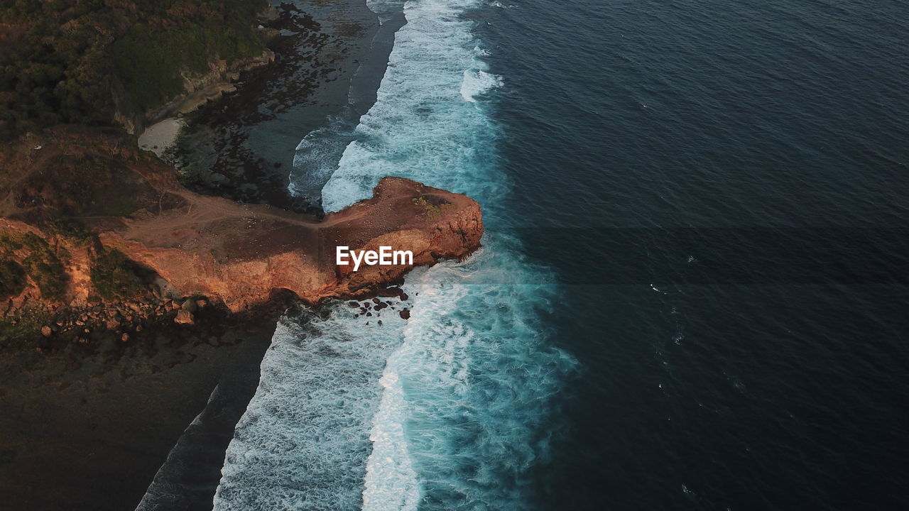 Aerial view of waves crashing on rocky coastline