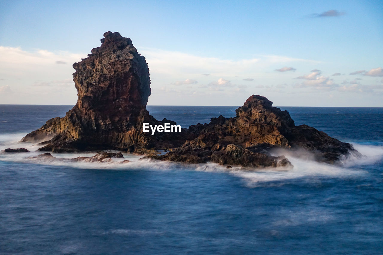 Rock formation on sea against sky