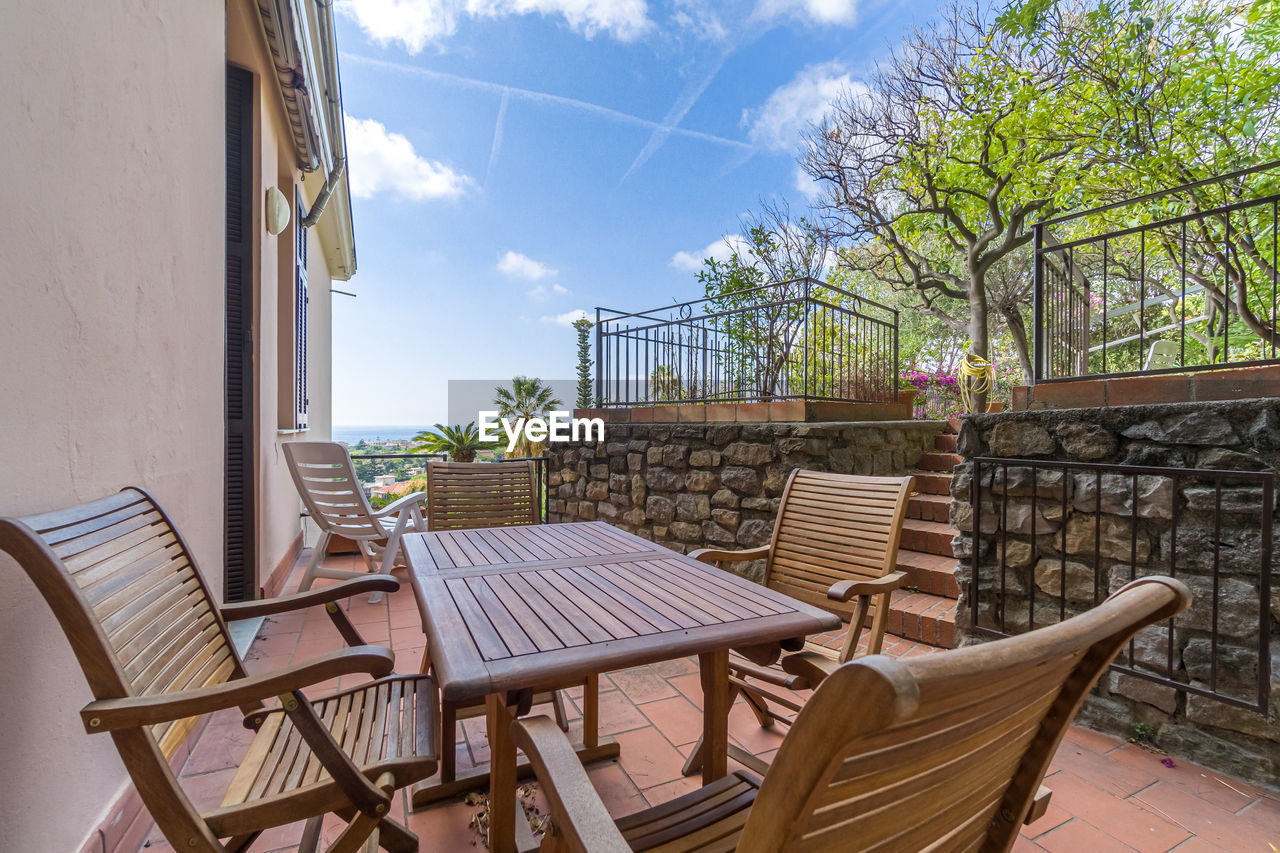 chair, seat, architecture, sky, table, nature, estate, furniture, built structure, building exterior, building, no people, cloud, plant, home, cottage, day, relaxation, villa, outdoors, tree, patio, empty, wood, real estate, absence, travel destinations, summer, outdoor structure, residential district, house, backyard, sunlight, outdoor chair, vacation, trip, tranquility, holiday, water, food and drink, city, restaurant, front or back yard, travel, balcony, cafe, business, luxury