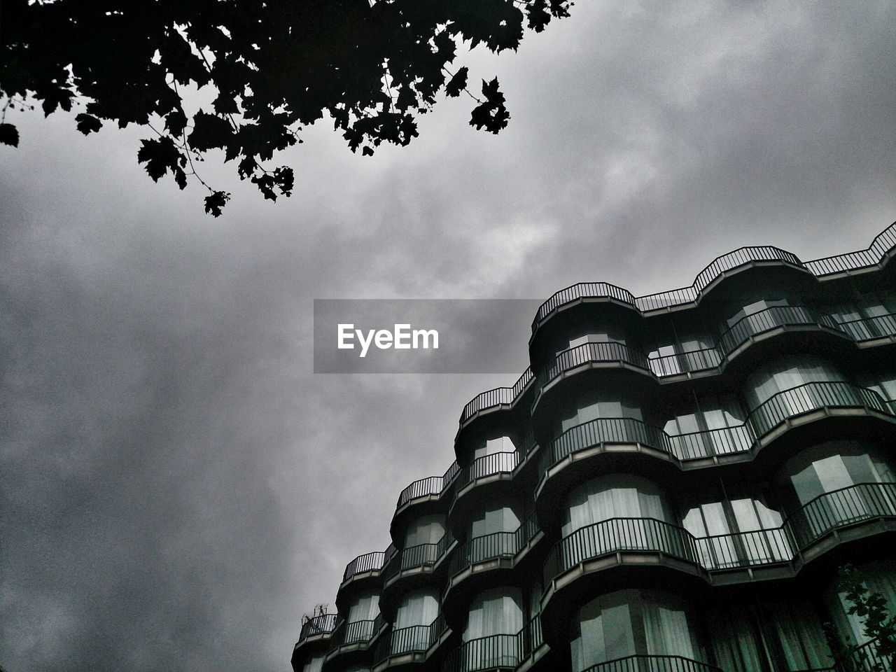 LOW ANGLE VIEW OF BUILDINGS AGAINST CLOUDY SKY