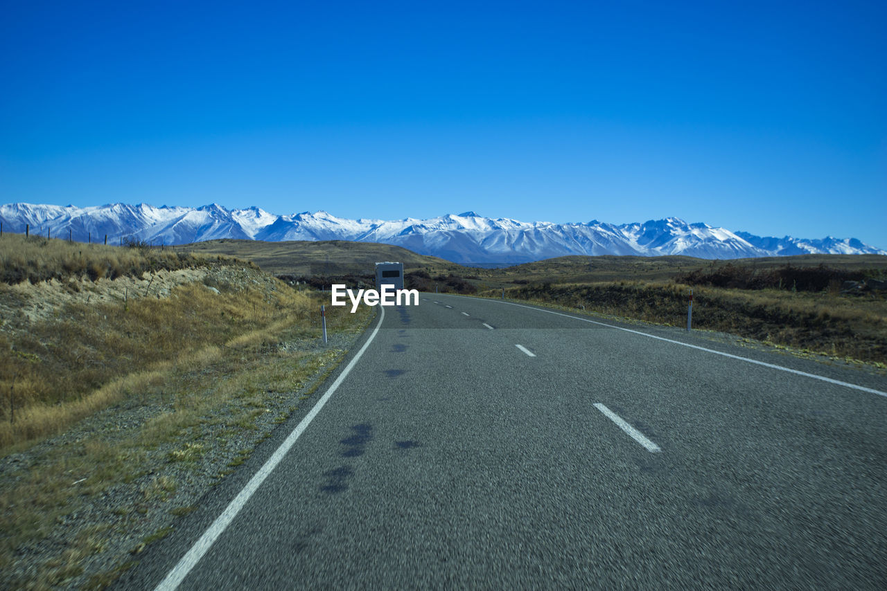 Road amidst landscape against clear blue sky