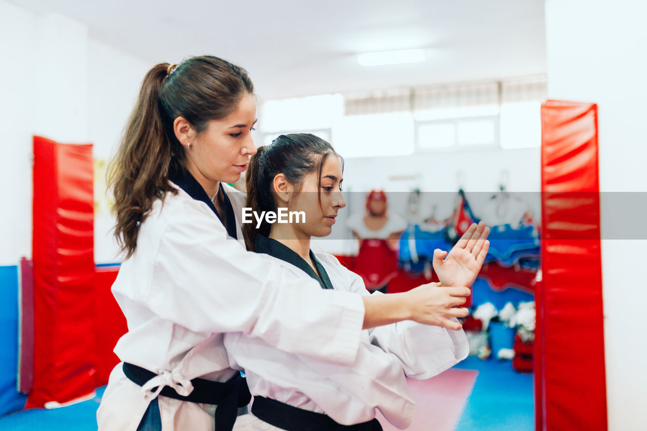 Taekwondo teacher guiding student during martial arts practice