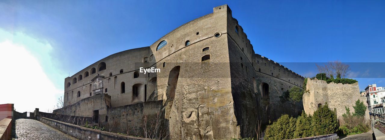 architecture, built structure, sky, building exterior, history, the past, nature, building, travel destinations, castle, wall, château, travel, blue, city, fort, clear sky, fortification, town, medieval, old, tourism, day, landmark, wall - building feature, outdoors, fortified wall, no people, sunny, cloud, surrounding wall, low angle view, panoramic, street, sunlight
