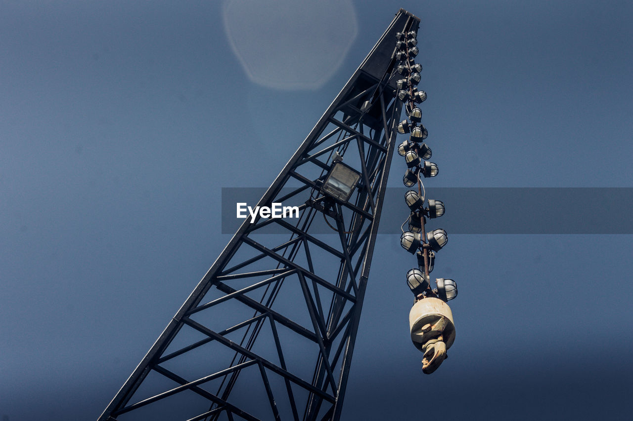 Low angle view of crane against clear blue sky