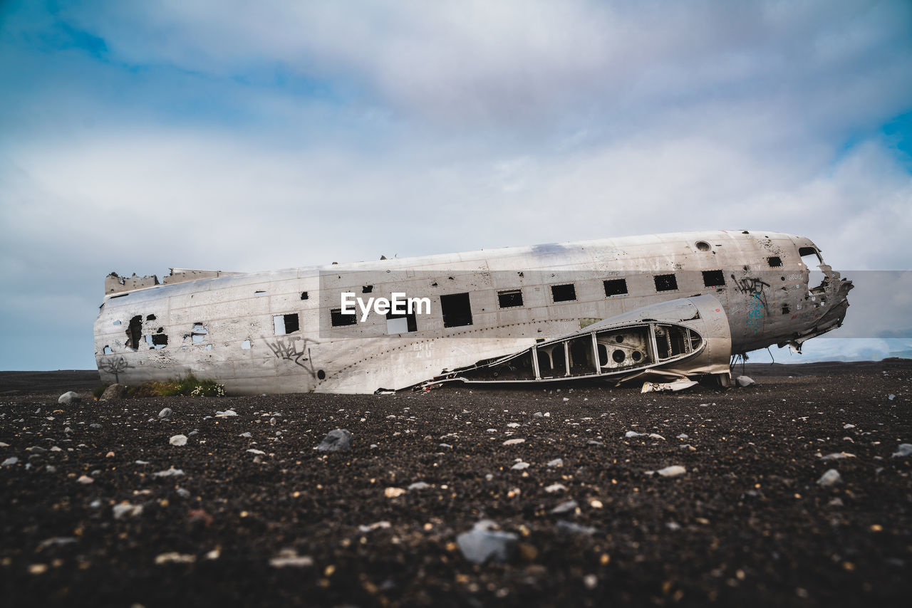 Abandoned airplane on field against sky