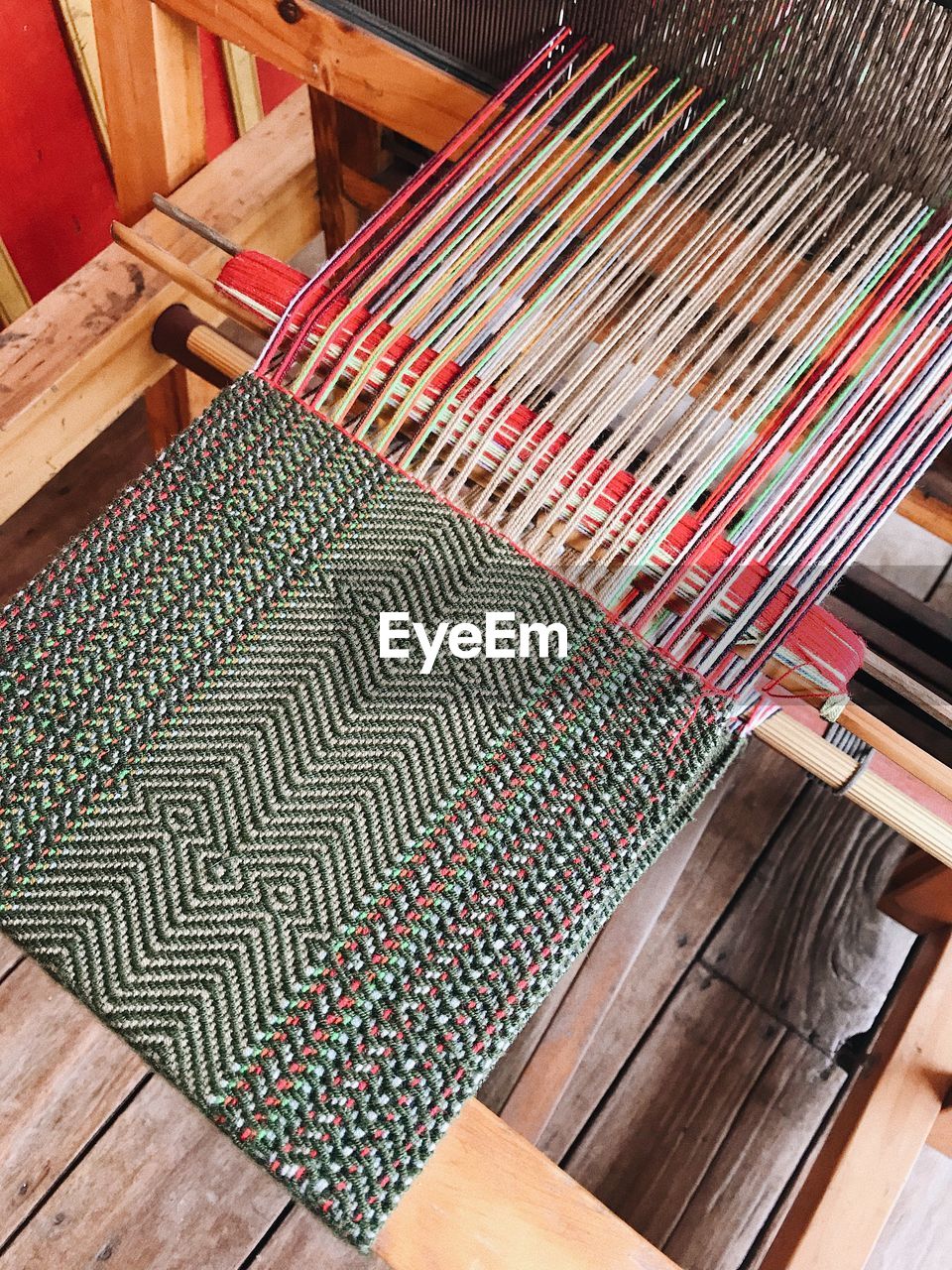 High angle view of multi colored fabric on loom in factory