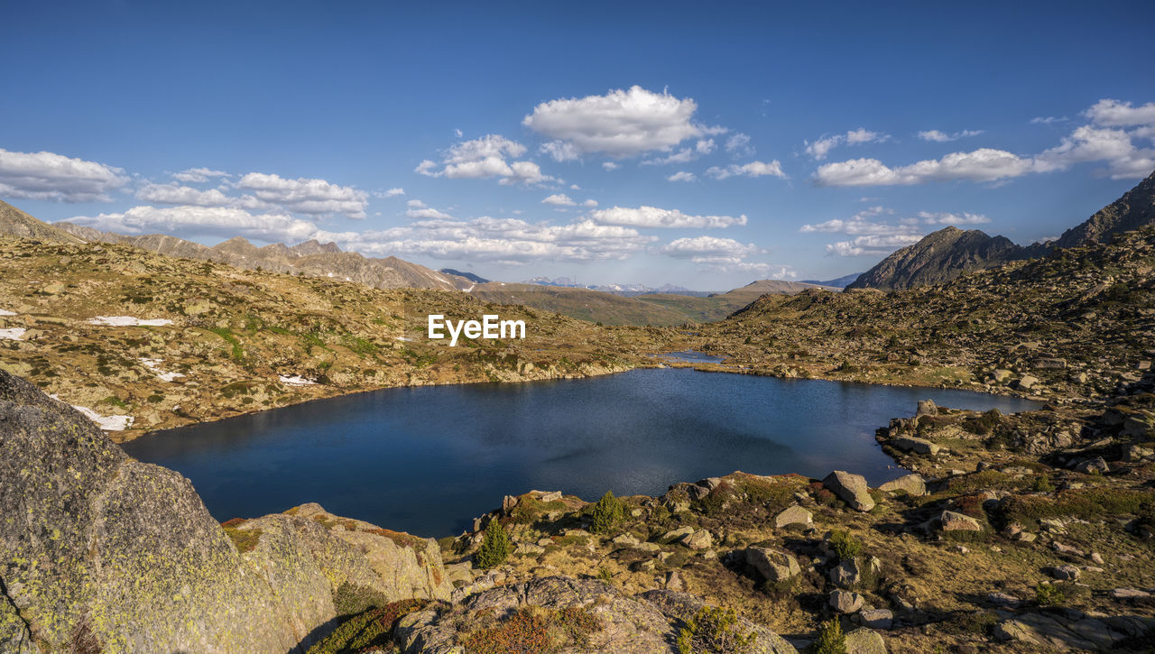 SCENIC VIEW OF LAKE BY MOUNTAIN AGAINST SKY