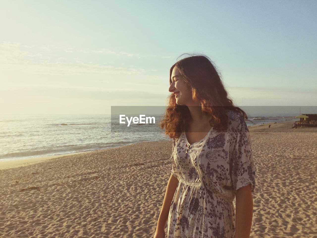 Happy woman standing on sand at beach