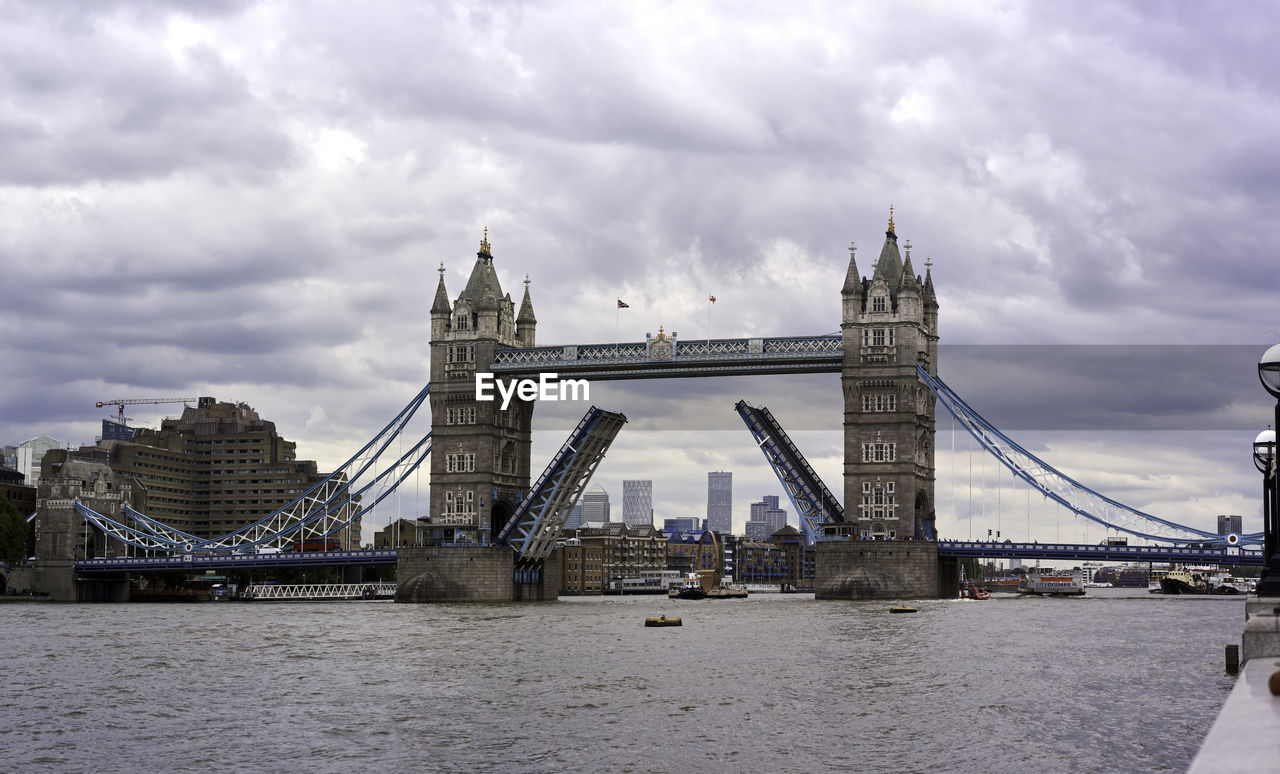 View of open bridge over river against cloudy sky