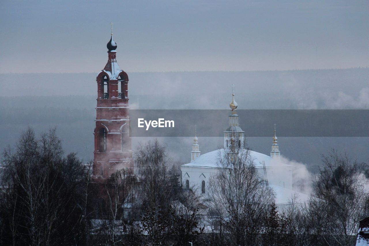 Buildings against sky during foggy weather