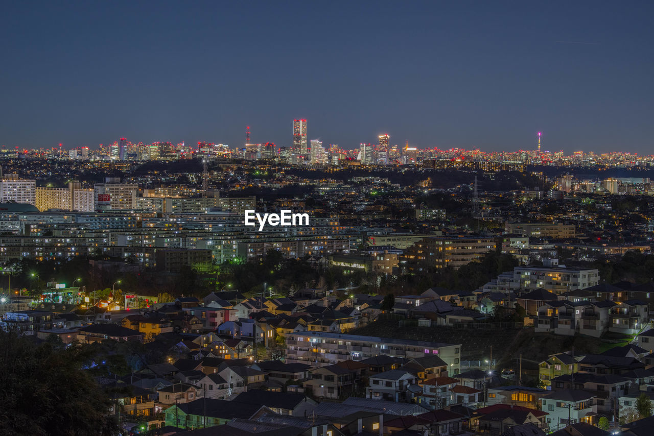 Illuminated cityscape against sky at night