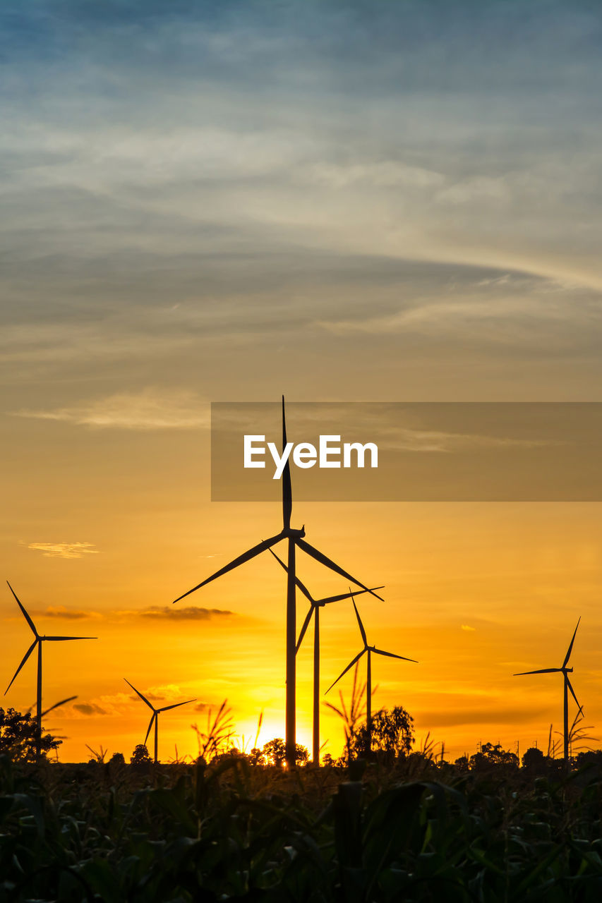 SILHOUETTE OF WIND TURBINES ON FIELD AGAINST SKY