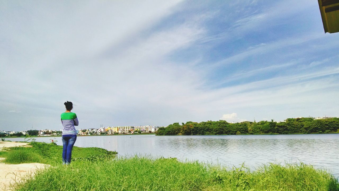 REAR VIEW OF MAN WITH UMBRELLA AGAINST SKY