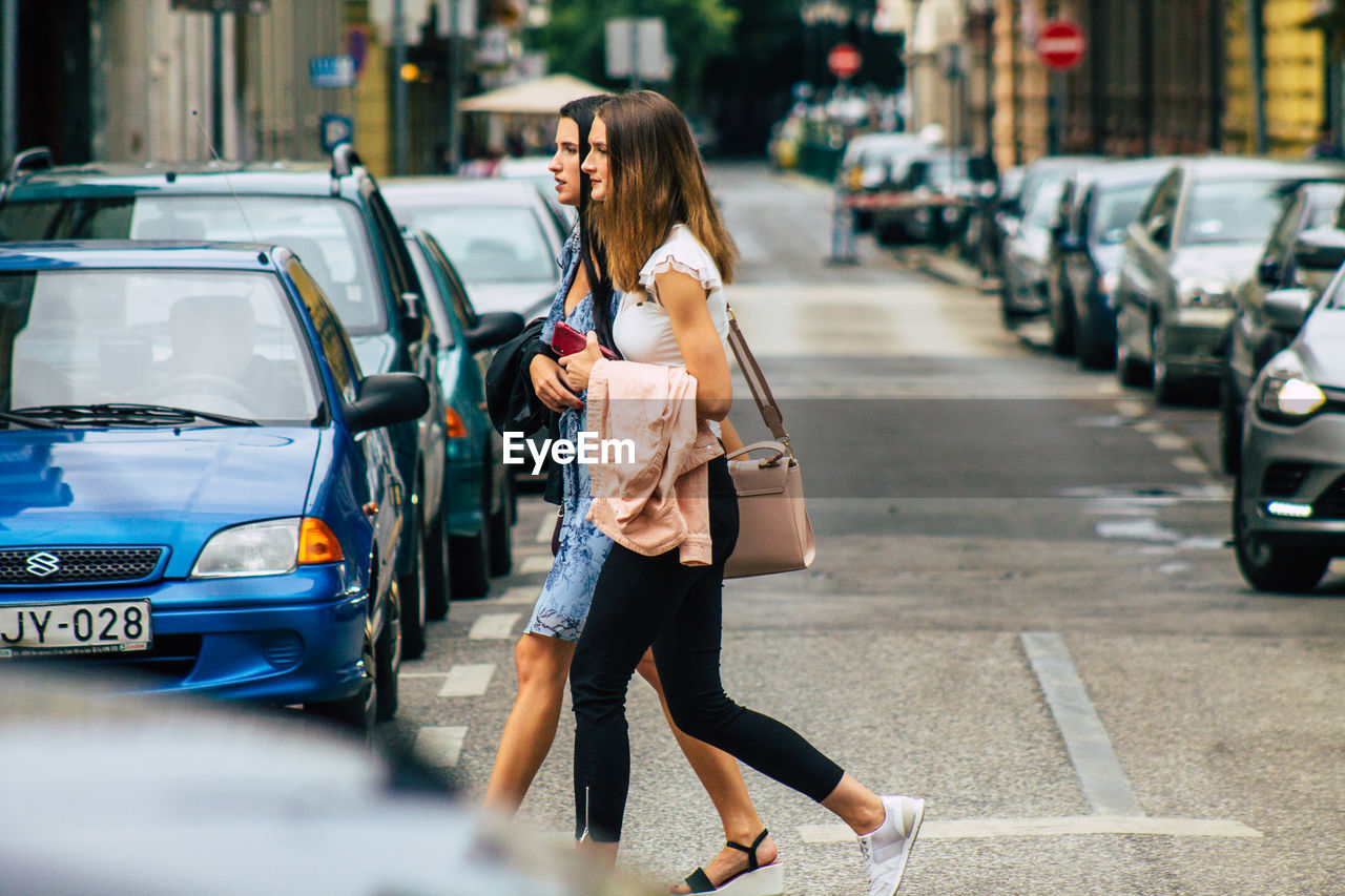 FULL LENGTH OF WOMAN WALKING ON STREET