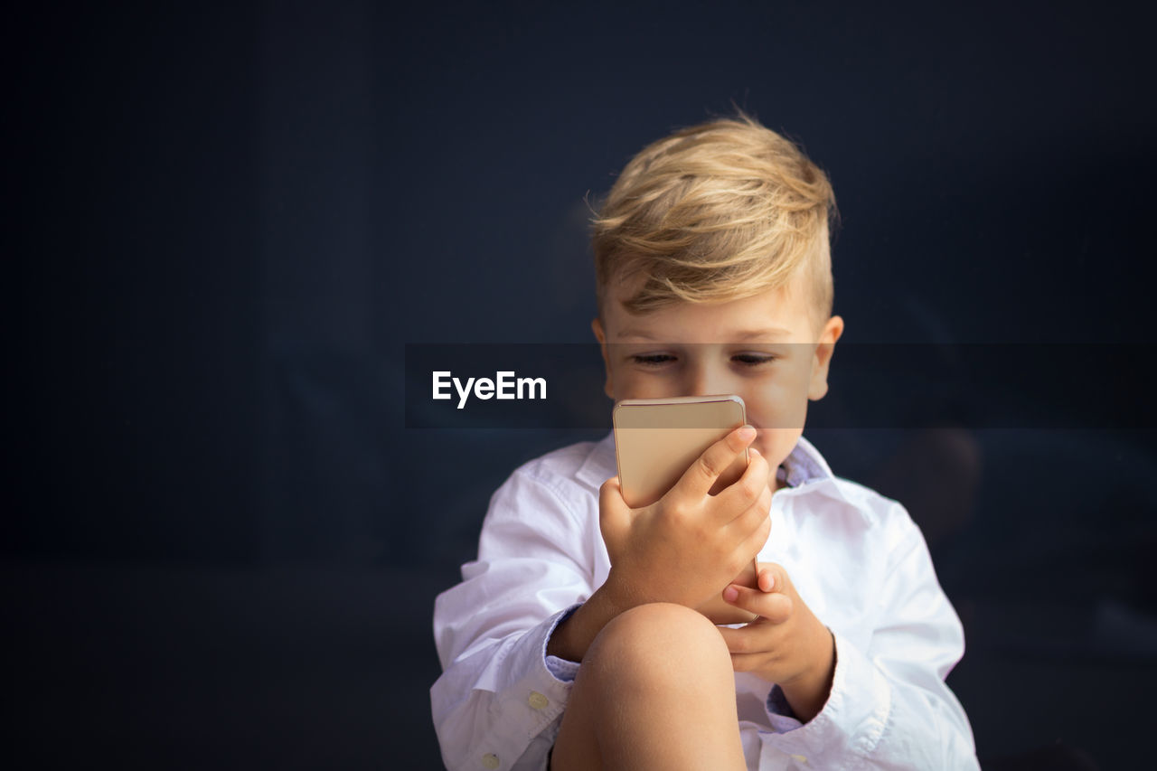 Happy little boy watching cartoons on mobile phone. focus is on hands and phone.