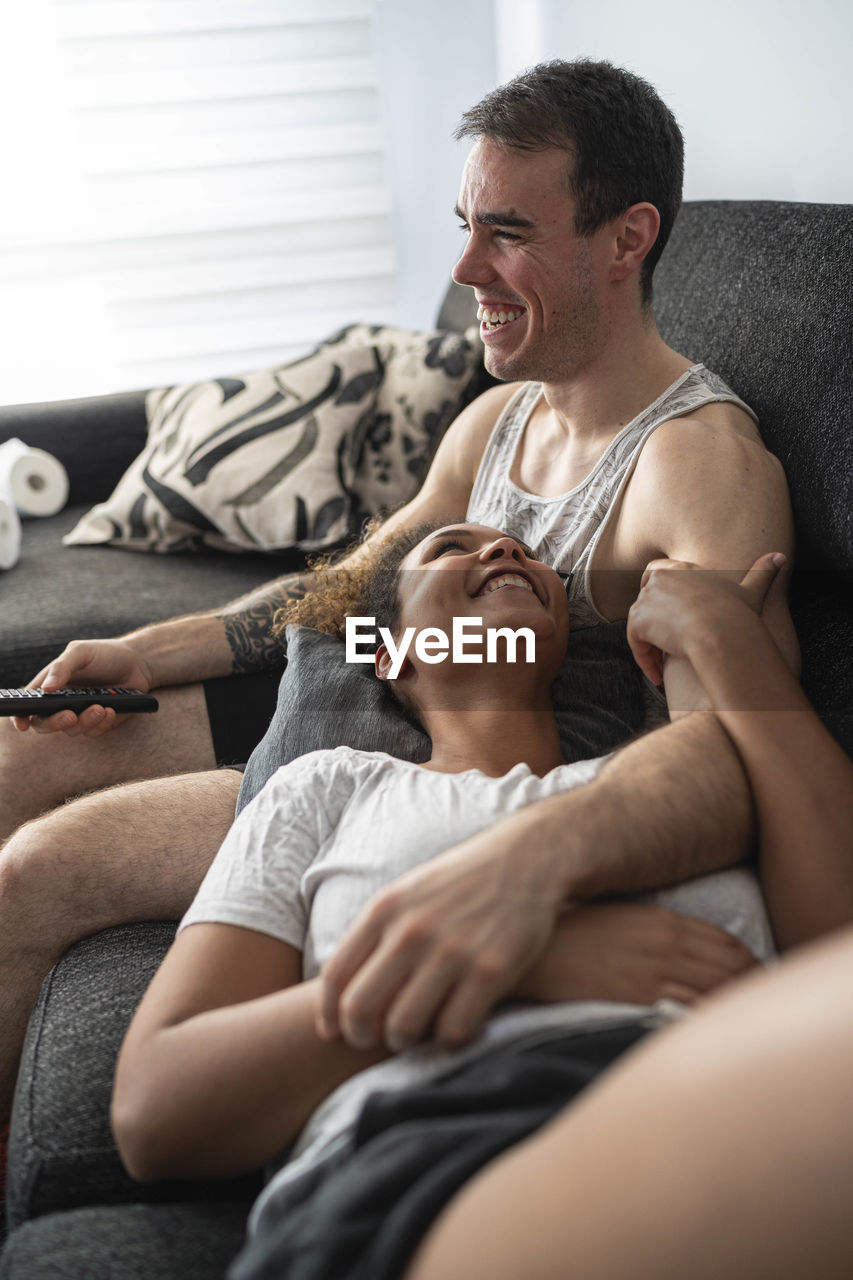Smiling couple relaxing on sofa at home