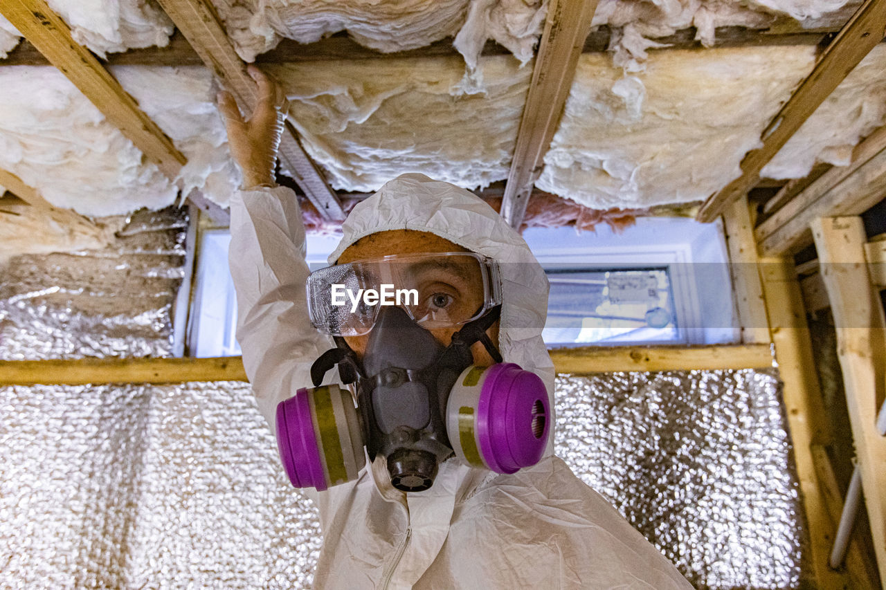 Portrait of man working on ceiling