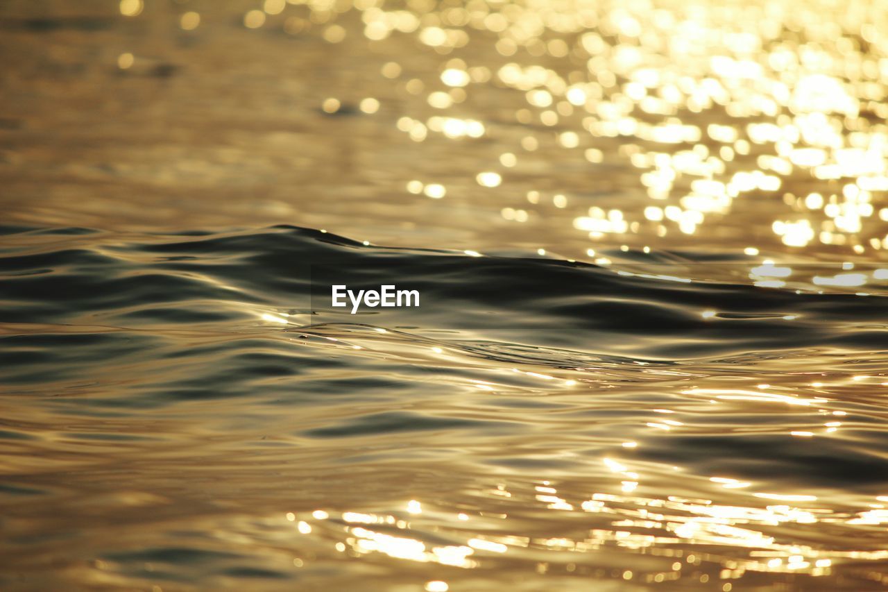 CLOSE-UP OF ILLUMINATED RIPPLED WATER