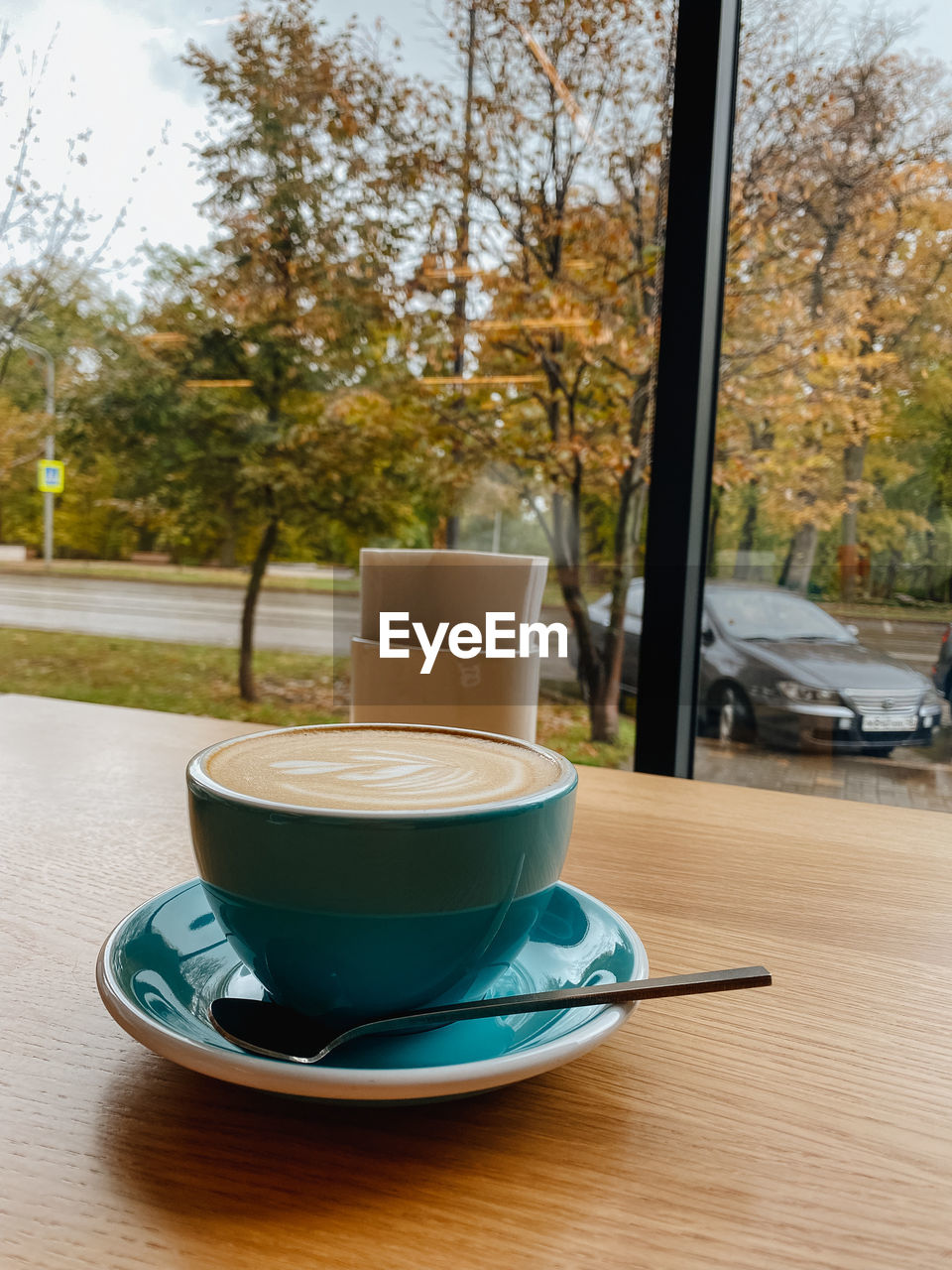 COFFEE CUP ON TABLE BY TREE