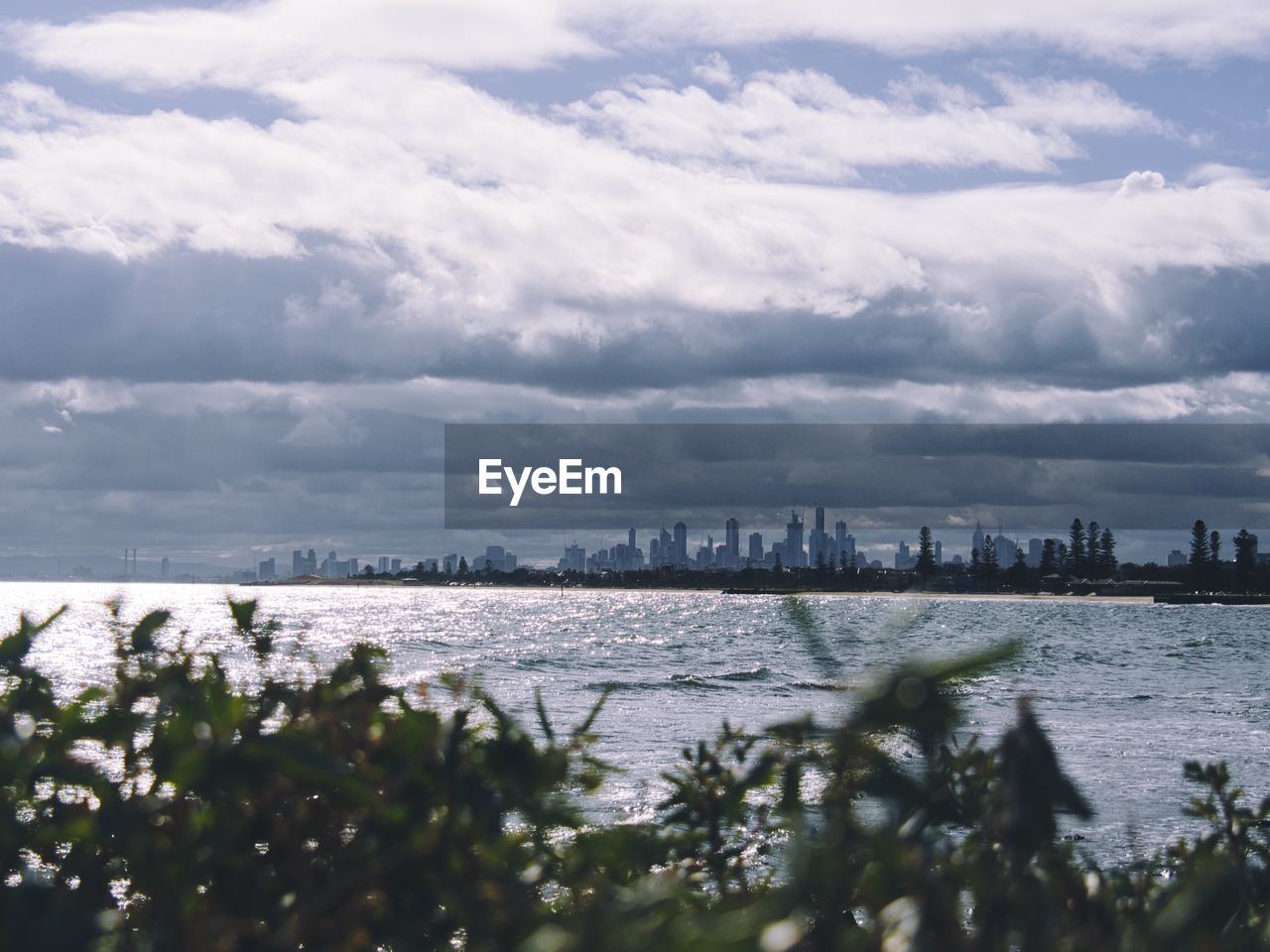 View of buildings in sea against cloudy sky