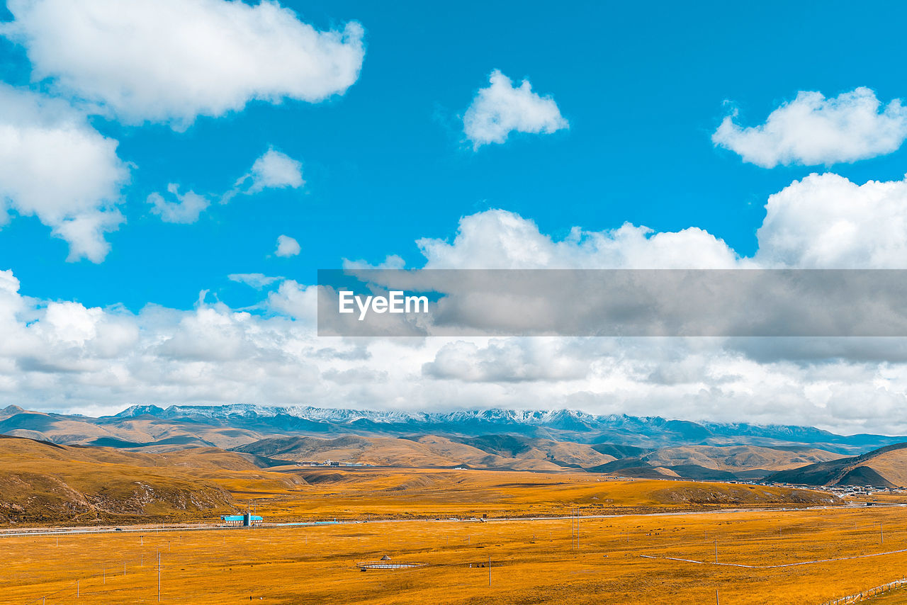 landscape, environment, sky, cloud, scenics - nature, grassland, beauty in nature, horizon, prairie, nature, mountain, land, plain, travel, field, travel destinations, tranquility, blue, rural scene, no people, mountain range, tranquil scene, steppe, non-urban scene, tourism, natural environment, plateau, grass, outdoors, snow, rural area, meadow, day, idyllic, plant, agriculture, cloudscape, cold temperature, road, social issues, environmental conservation, sunlight, summer, winter, remote, semi-arid, yellow, vacation, trip, water, dramatic sky, holiday, panoramic, valley, awe, wilderness, sunny, vibrant color, autumn