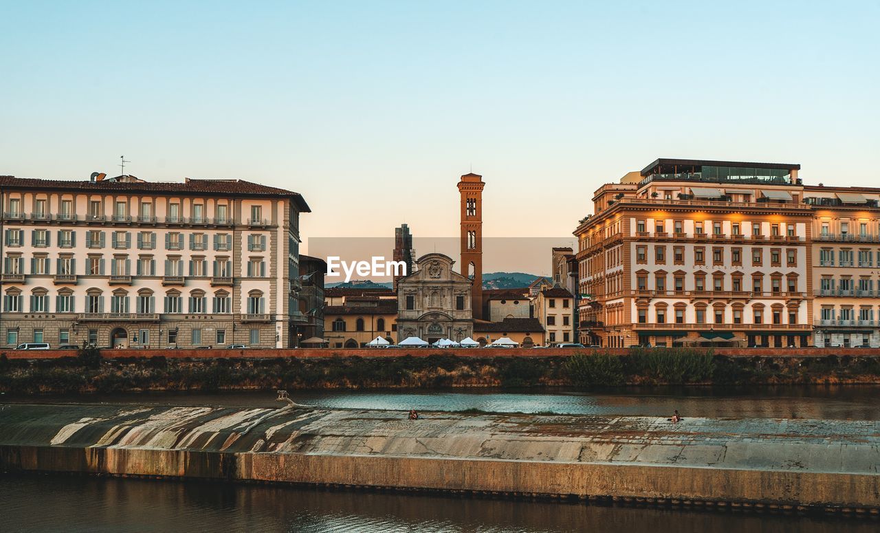 Buildings in city against clear sky